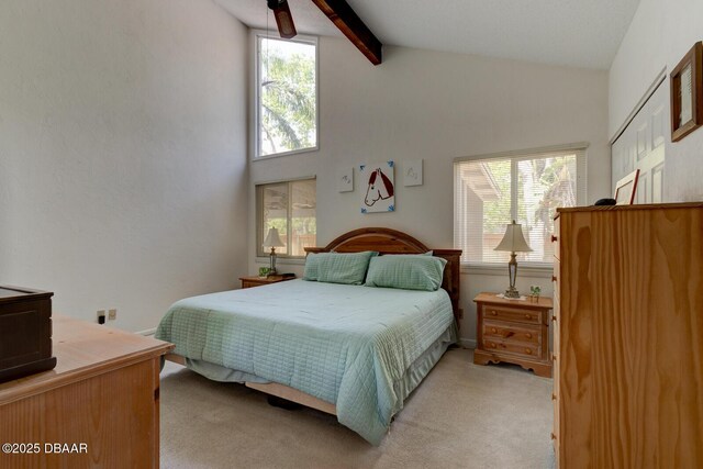 bedroom featuring multiple windows, light carpet, and beam ceiling