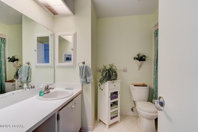 full bath with vanity, baseboards, tile patterned floors, and toilet