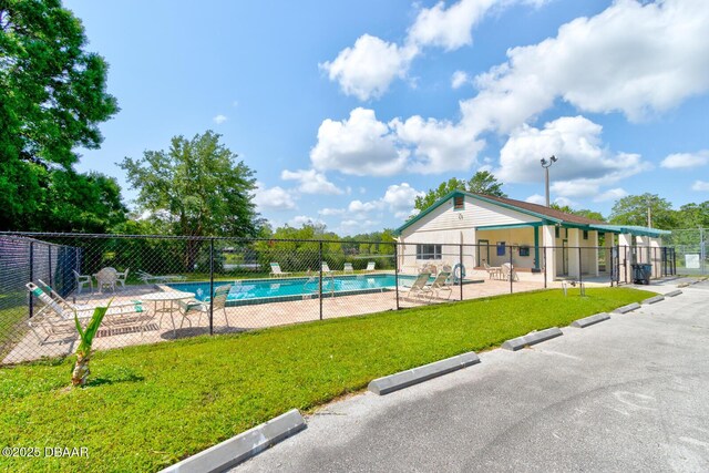 pool with fence, a yard, and a patio area