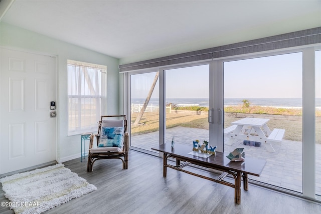 sunroom featuring a water view