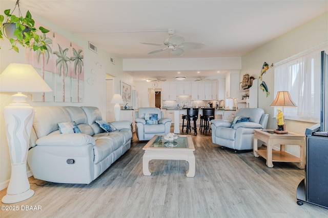 living room featuring light hardwood / wood-style flooring and ceiling fan