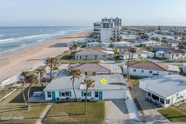 birds eye view of property with a water view and a view of the beach