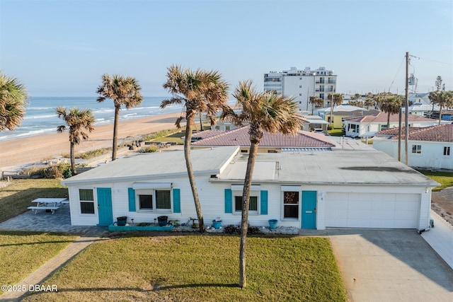 view of front of house featuring a garage, a water view, and a front yard