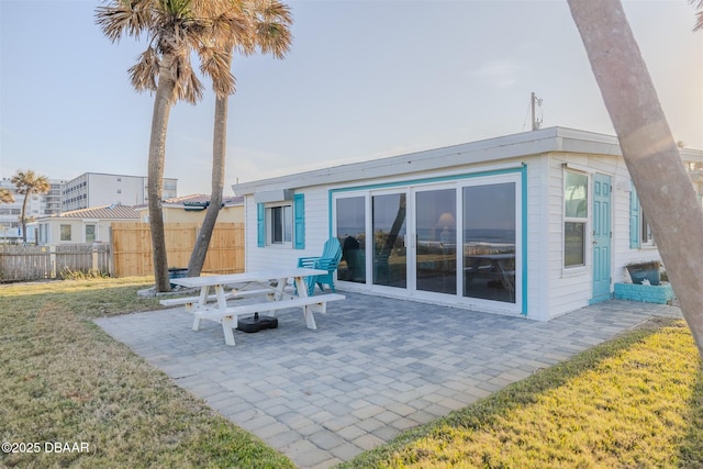 back of house featuring a lawn and a patio area