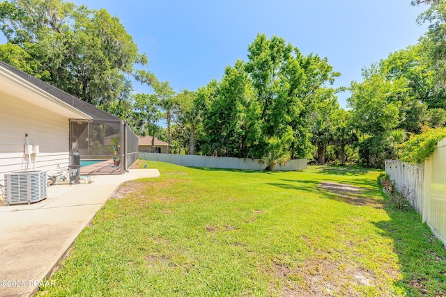 3931 Tano Dr, Ormond Beach, FL 32174 - view of yard featuring a patio, glass enclosure, and central AC unit