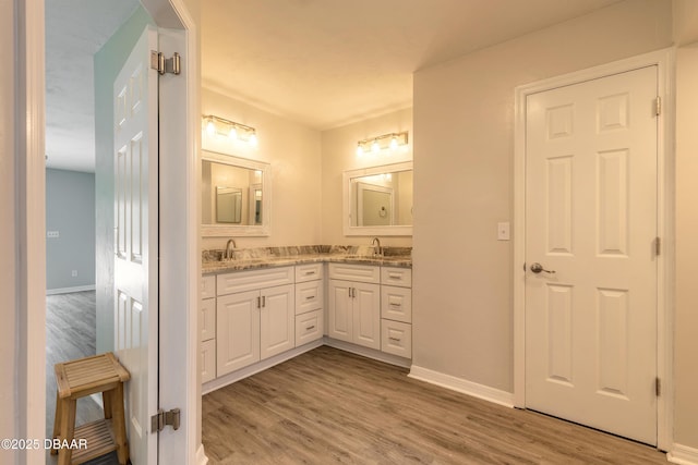 3931 Tano Dr, Ormond Beach, FL 32174 - bathroom featuring double vanity, wood finished floors, and baseboards