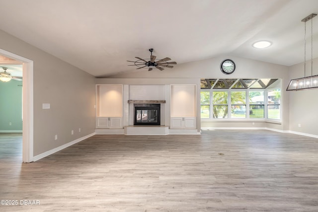 3931 Tano Dr, Ormond Beach, FL 32174 - unfurnished living room featuring a ceiling fan, lofted ceiling, a glass covered fireplace, and wood finished floors