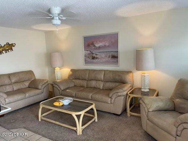 living room featuring ceiling fan, a textured ceiling, and carpet floors