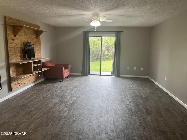 unfurnished living room featuring a textured ceiling, dark wood-style flooring, a ceiling fan, and baseboards