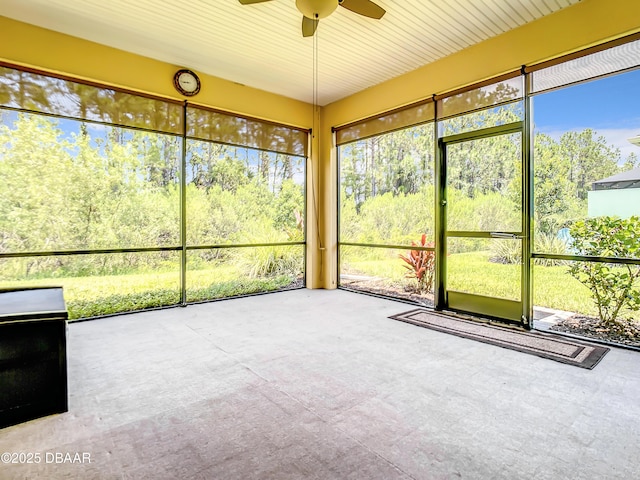 unfurnished sunroom featuring ceiling fan