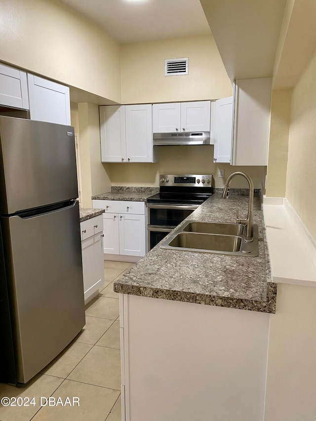 kitchen with sink, white cabinets, stainless steel appliances, and light tile patterned floors