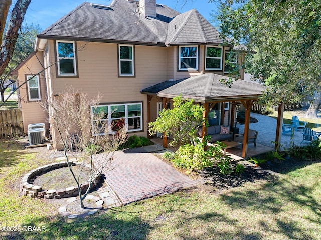 rear view of house with an outdoor living space, a yard, a patio area, and central air condition unit