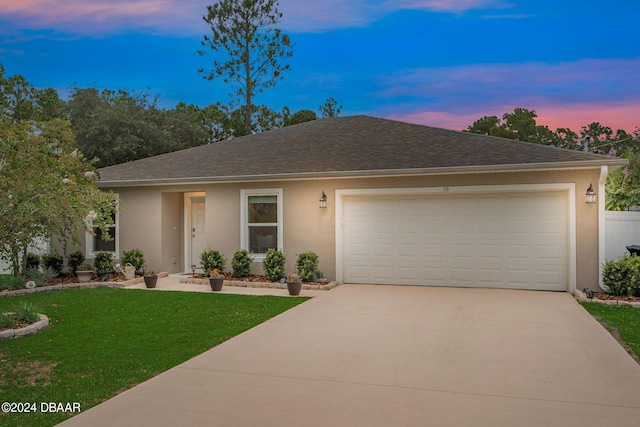 ranch-style home featuring a garage and a lawn