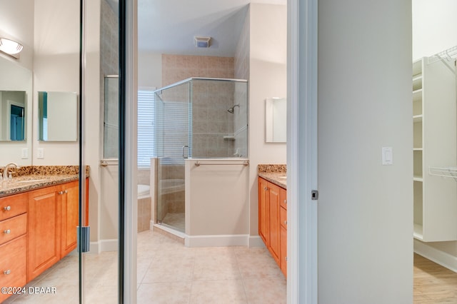 bathroom featuring vanity, tile patterned floors, and a shower with shower door