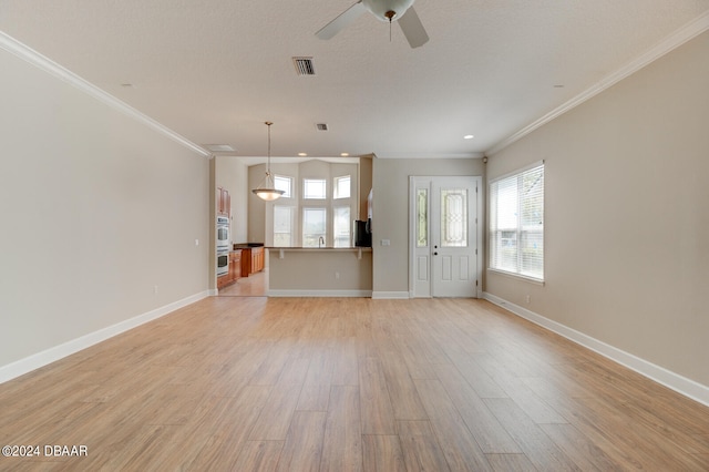 unfurnished living room with ornamental molding, light wood-type flooring, a textured ceiling, and ceiling fan