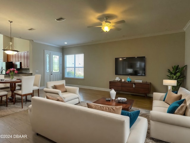 living room featuring light wood-type flooring, ceiling fan, and crown molding