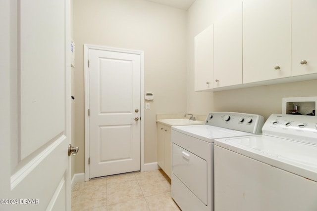 washroom with sink, cabinets, independent washer and dryer, and light tile patterned floors