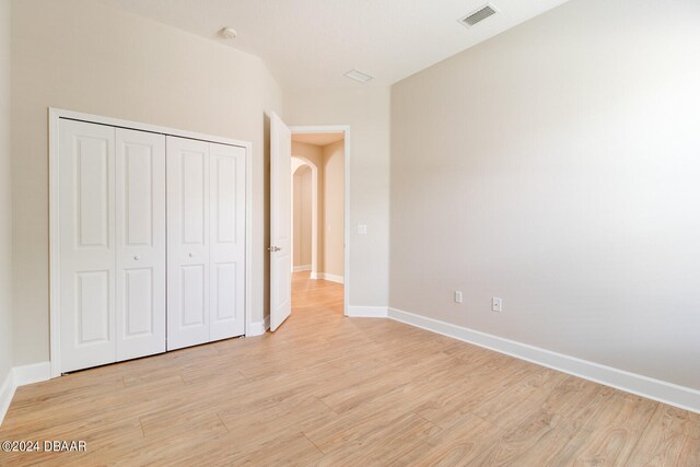 unfurnished bedroom featuring a closet and light hardwood / wood-style floors