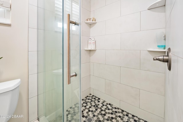 bathroom with toilet and an enclosed shower