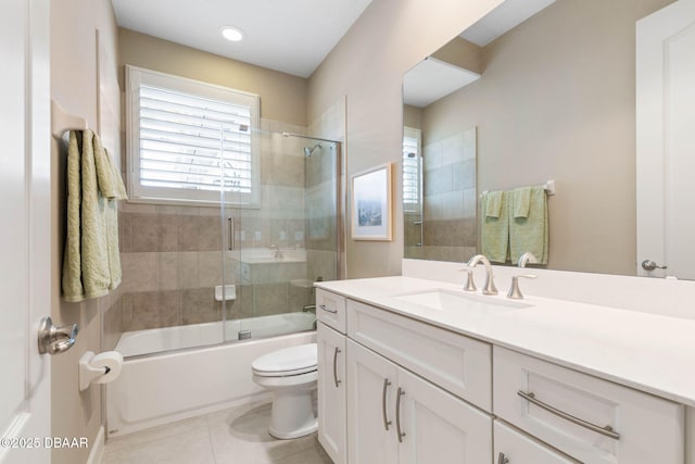 full bathroom with tile patterned flooring, toilet, vanity, and combined bath / shower with glass door