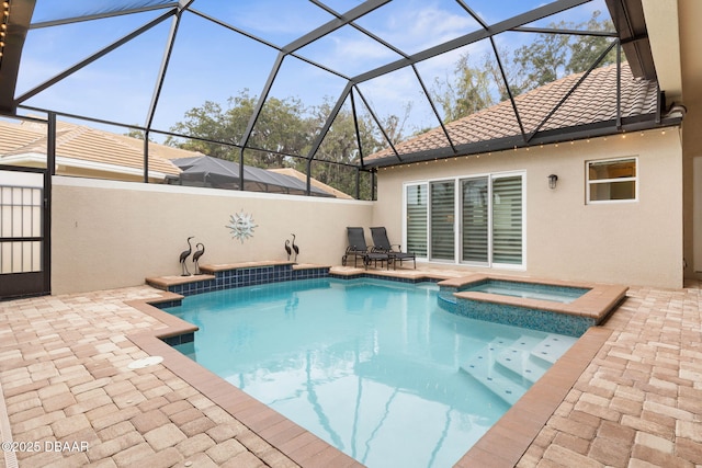 view of swimming pool featuring a patio, an in ground hot tub, and a lanai