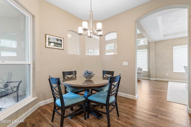 dining area featuring dark wood-type flooring and a chandelier