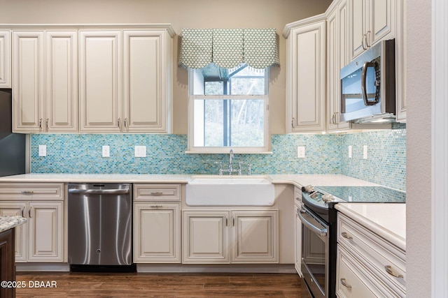 kitchen featuring stainless steel appliances, tasteful backsplash, dark wood-type flooring, and sink