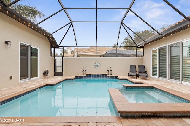 view of pool with an in ground hot tub, glass enclosure, and a patio area