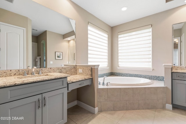 bathroom featuring tile patterned floors, vanity, and a relaxing tiled tub