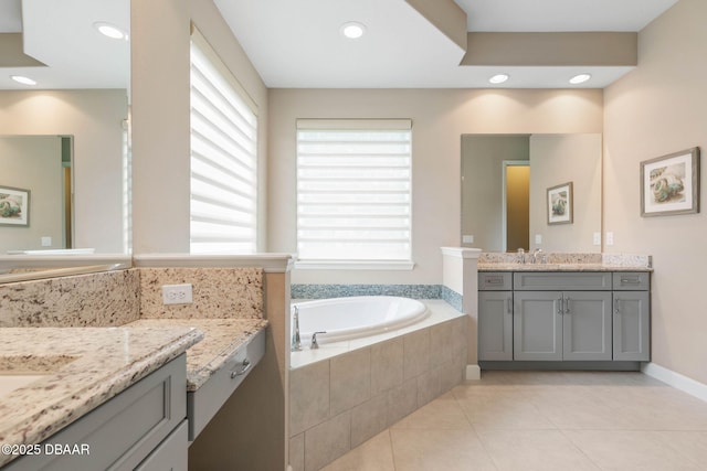 bathroom with vanity, a relaxing tiled tub, tile patterned floors, and a healthy amount of sunlight