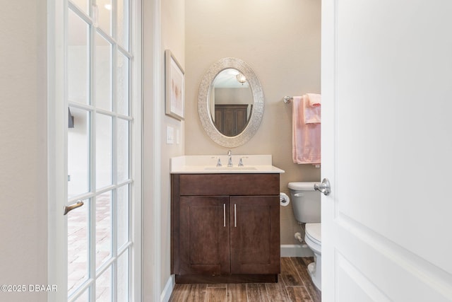 bathroom featuring vanity, toilet, and hardwood / wood-style floors