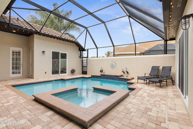 view of swimming pool featuring a patio area, an in ground hot tub, and a lanai