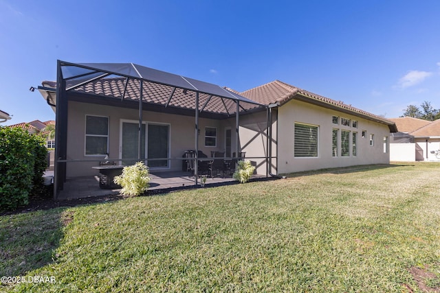 rear view of property featuring a lanai, a lawn, and a patio area