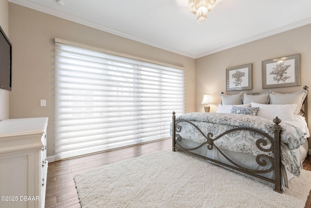 bedroom with hardwood / wood-style flooring and crown molding