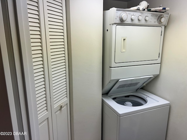 laundry room featuring stacked washer / drying machine