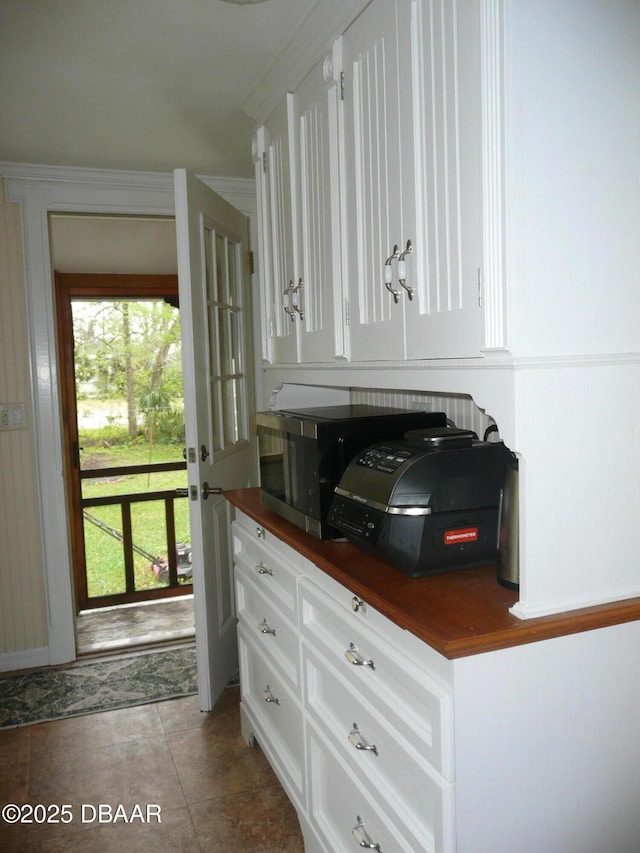 kitchen featuring dark countertops, tile patterned flooring, and white cabinets