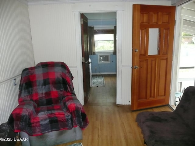 living area with cooling unit and light wood-style flooring