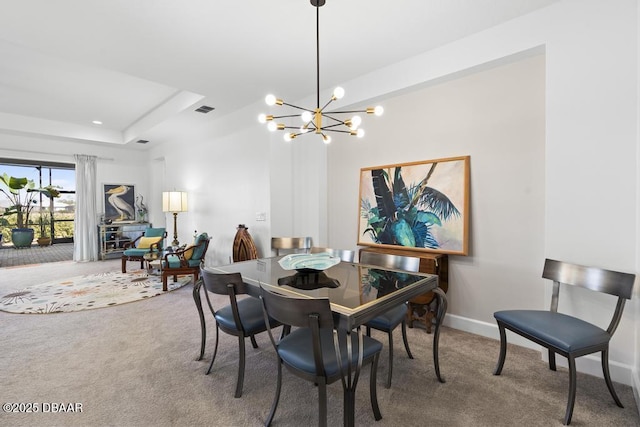 dining room featuring a raised ceiling, carpet floors, and a chandelier