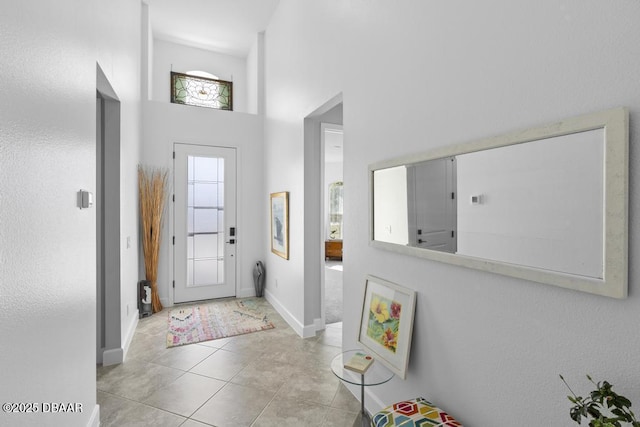 foyer with light tile patterned floors and a high ceiling