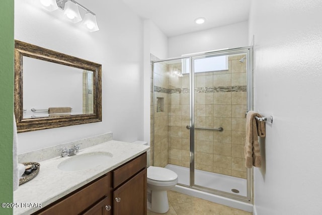 bathroom featuring vanity, toilet, a shower with shower door, and tile patterned flooring