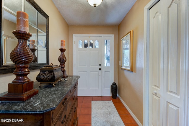 tiled foyer with a textured ceiling