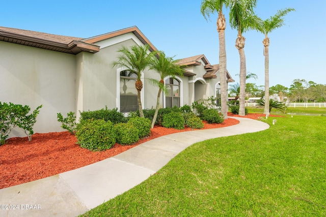540 Leeway Trl, Ormond Beach, FL 32174 - view of side of home with stucco siding, a lawn, and roof with shingles