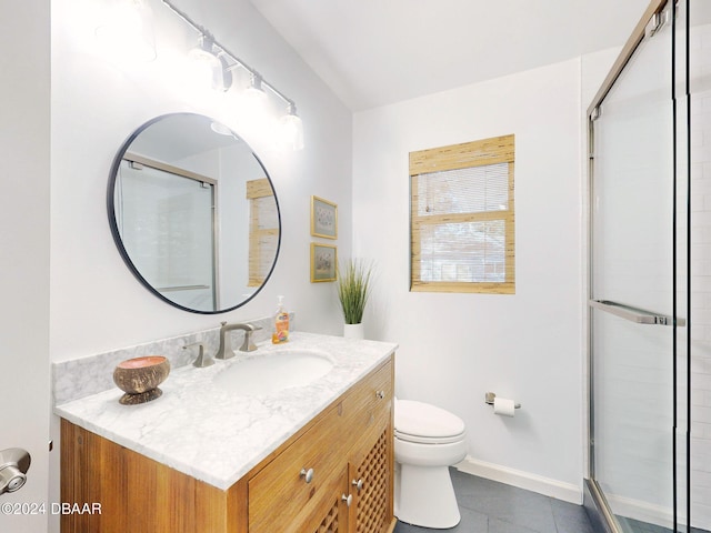 bathroom with tile patterned floors, vanity, an enclosed shower, and toilet