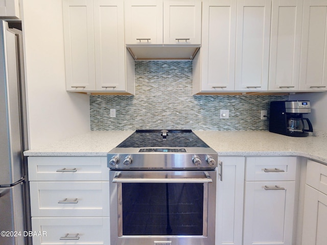 kitchen featuring backsplash, light stone counters, white cabinets, and appliances with stainless steel finishes