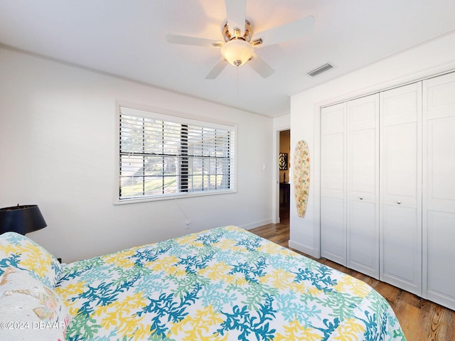 bedroom with a closet, dark hardwood / wood-style floors, and ceiling fan