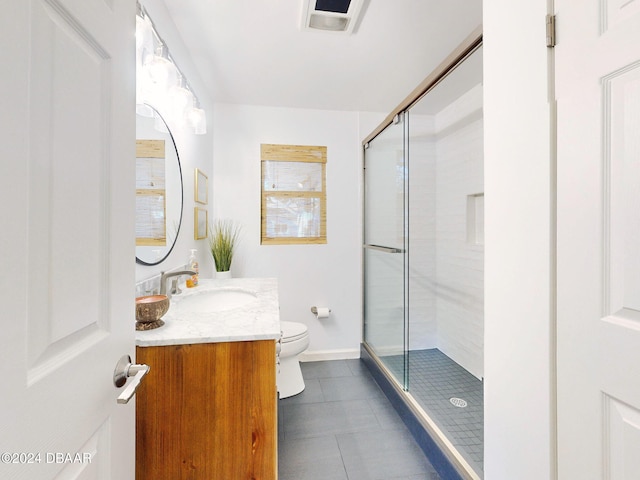 bathroom featuring tile patterned floors, vanity, toilet, and a shower with door