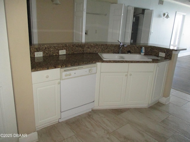 2055 S Atlantic Ave Unit 1004, Daytona Beach, FL 32118 - kitchen featuring white dishwasher, a peninsula, dark stone countertops, and white cabinets
