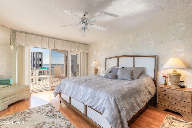 bedroom featuring ceiling fan, access to exterior, and light hardwood / wood-style flooring