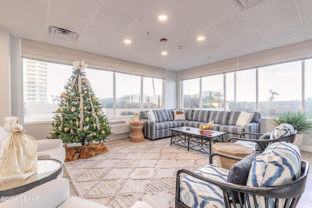 sunroom with a drop ceiling and an AC wall unit