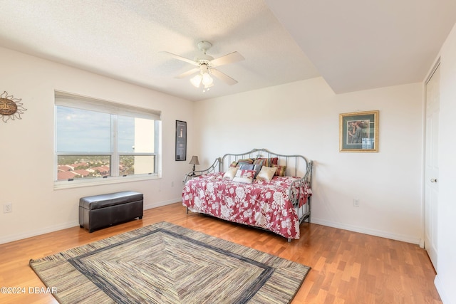 bedroom featuring ceiling fan, a textured ceiling, and hardwood / wood-style floors